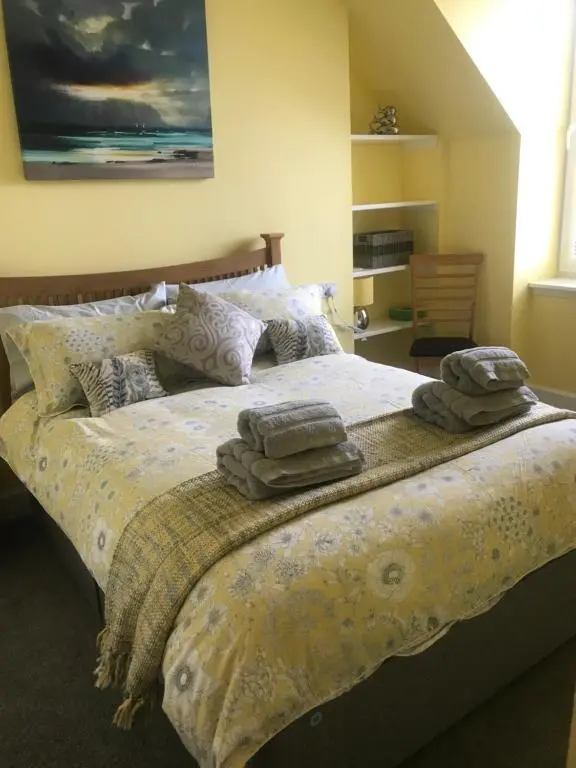 a bedroom with a bed with towels on it at Kenneth Street Apartment in Inverness