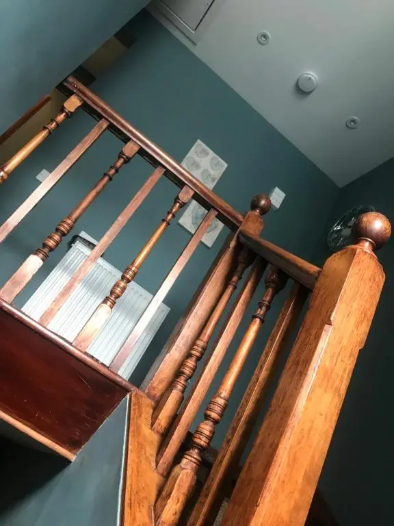 a wooden spiral staircase in a room with blue walls at Kenneth Street Apartment in Inverness