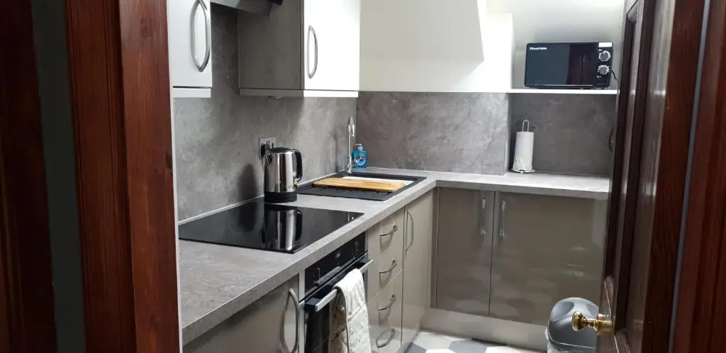 a kitchen with a sink and a stove at Kenneth Street Apartment in Inverness