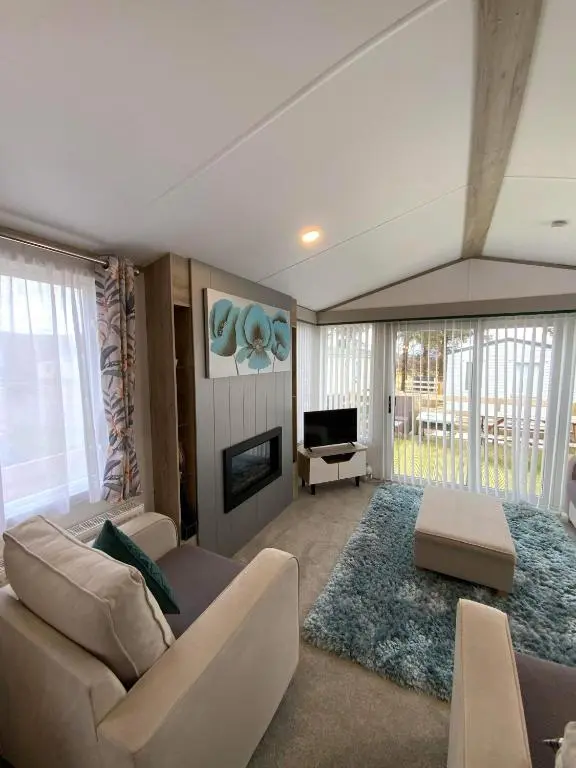 a living room with a couch and a fireplace at Dee Lodge in Boat of Garten