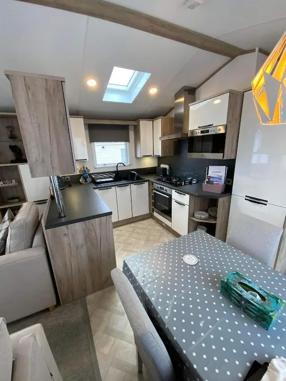 a kitchen with a table and a dining room at Dee Lodge in Boat of Garten