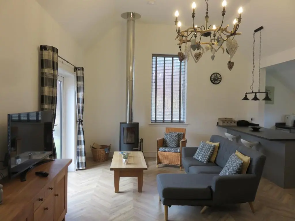 a living room with a couch and a table at Old Schoolhouse in Lairg