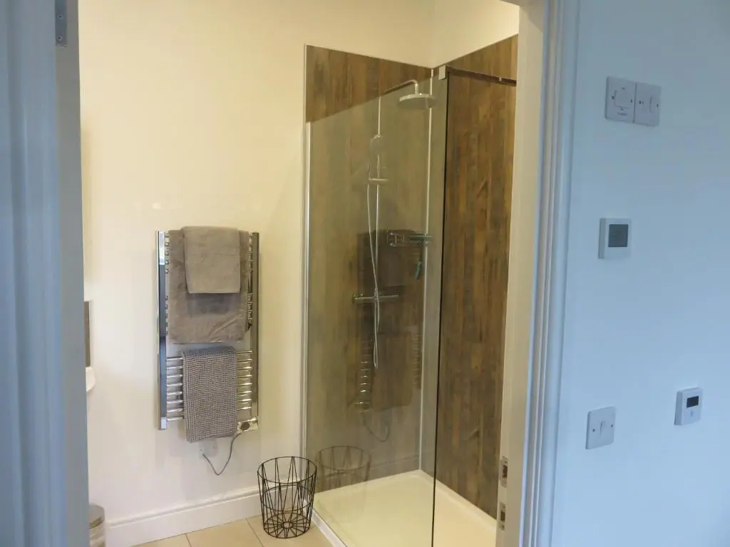 a shower with a glass door in a bathroom at Old Schoolhouse in Lairg