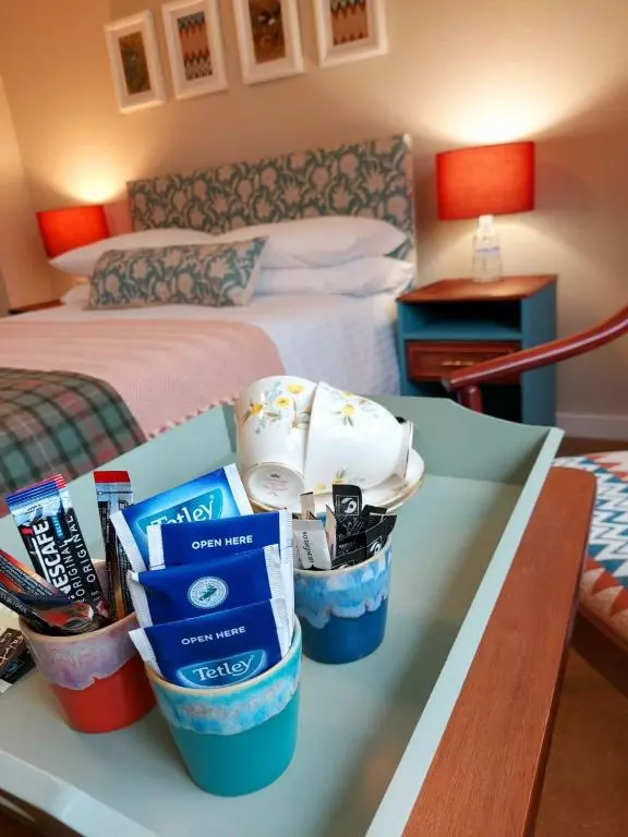 a table in a hotel room with a bed and a bedroom at The Cnoc Hotel in Beauly