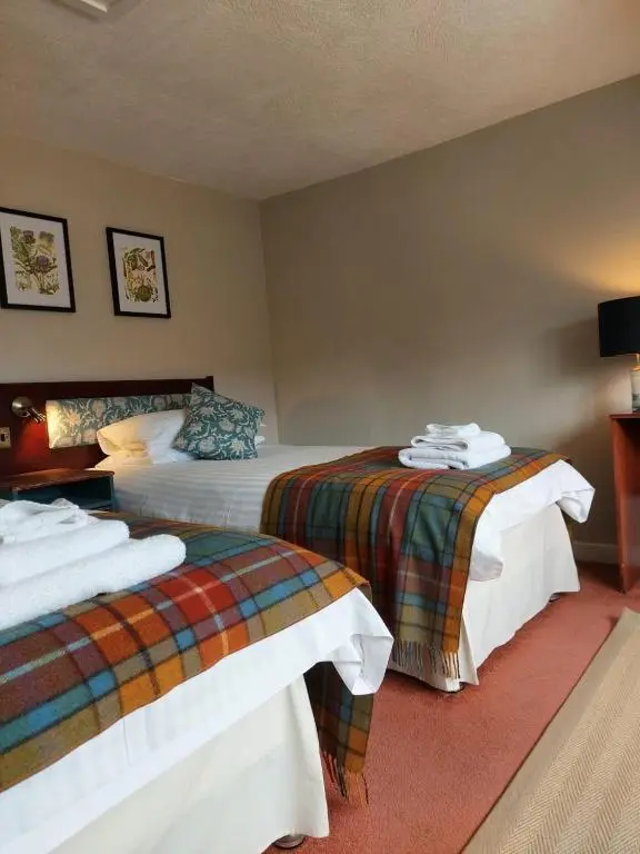 a hotel room with two beds in a room at The Cnoc Hotel in Beauly