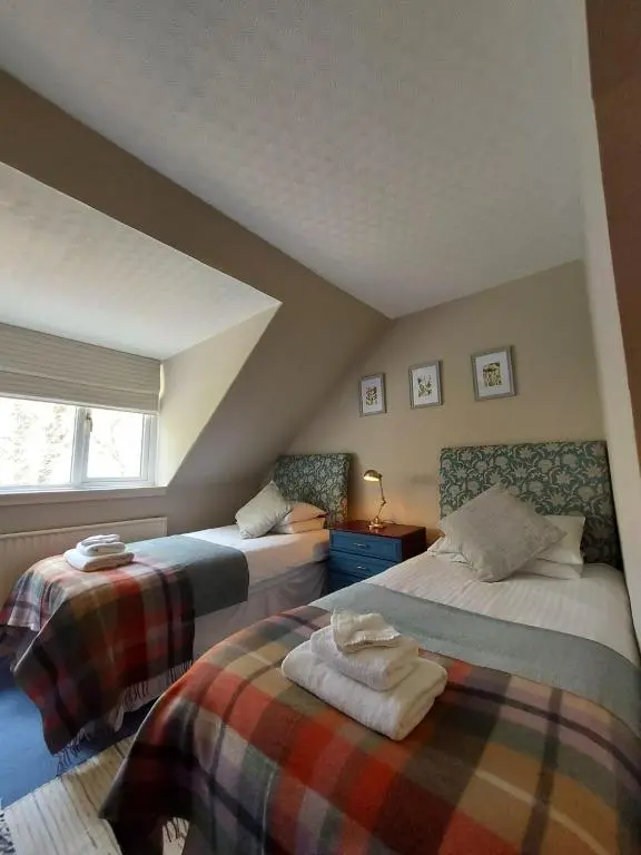 a bedroom with two beds and a window at The Cnoc Hotel in Beauly