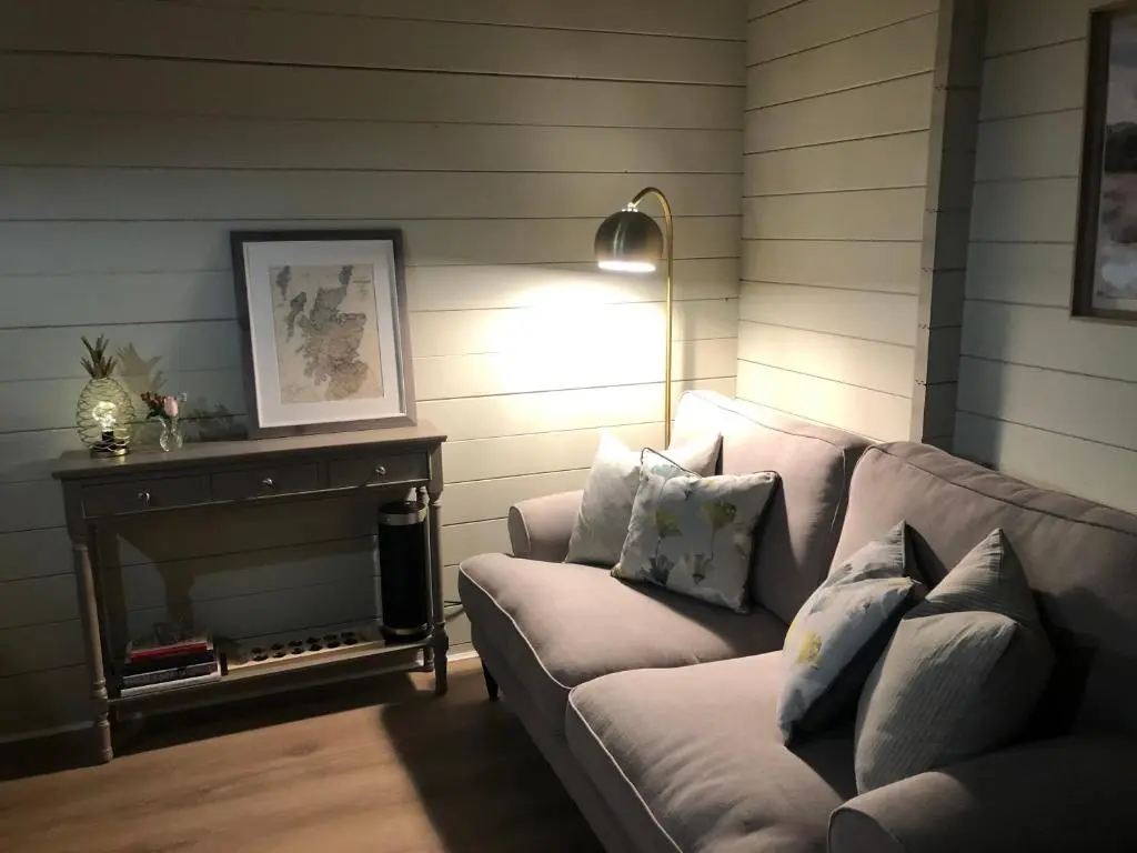 a living room with a couch and a fireplace at Highland cabin - relaxing hot tub in Inverness