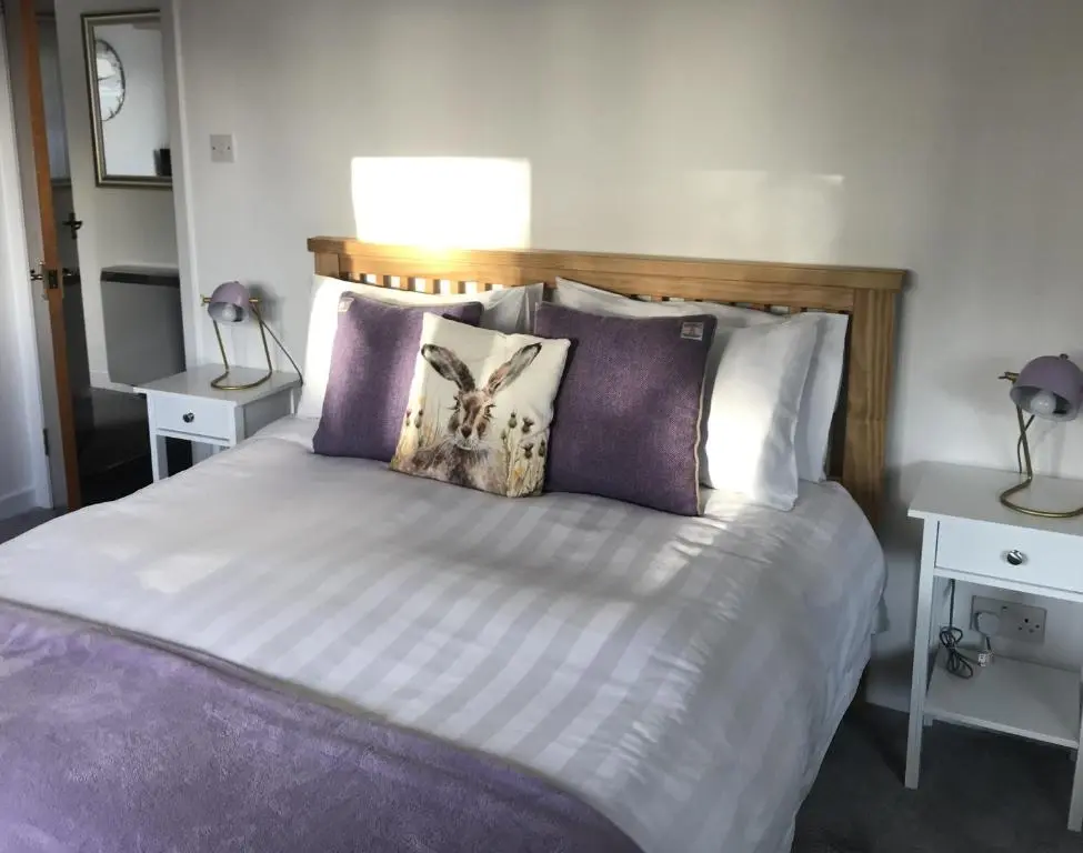 a bedroom with a bed with pillows on it at No. 9 in Inverness