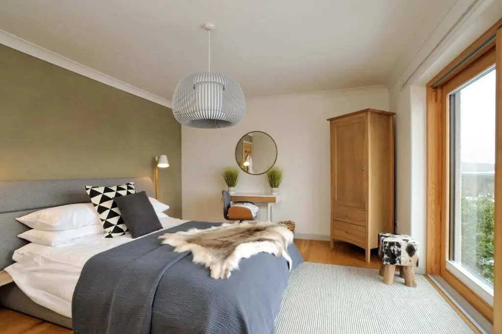 a bedroom with a bed and a large window at Tom's Lodge in Boat of Garten
