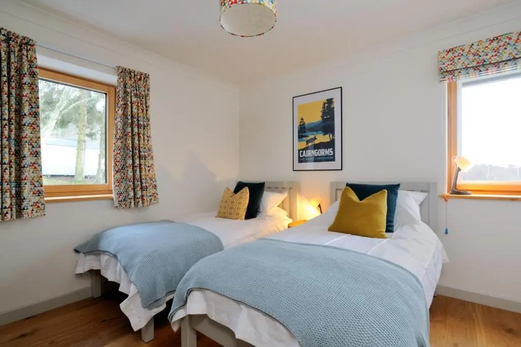 a bedroom with two beds and a window at Tom's Lodge in Boat of Garten