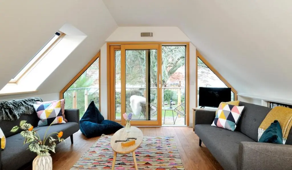 a living room with a couch and a table at Tom's Lodge in Boat of Garten