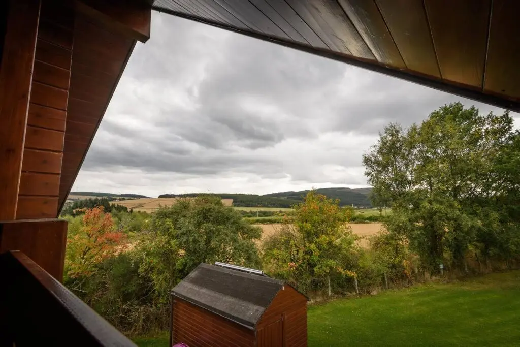 a view of a field from a window of a house at Red Squirrel log cabin with hot tub in Keith