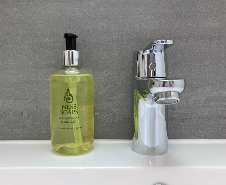 a bottle of moss sons soap next to a faucet at Berryfield Holiday Apartment in Inverness