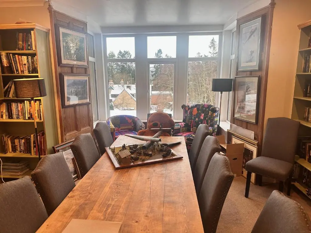 a dining room with a wooden table and chairs at Forces Manor in Kincraig
