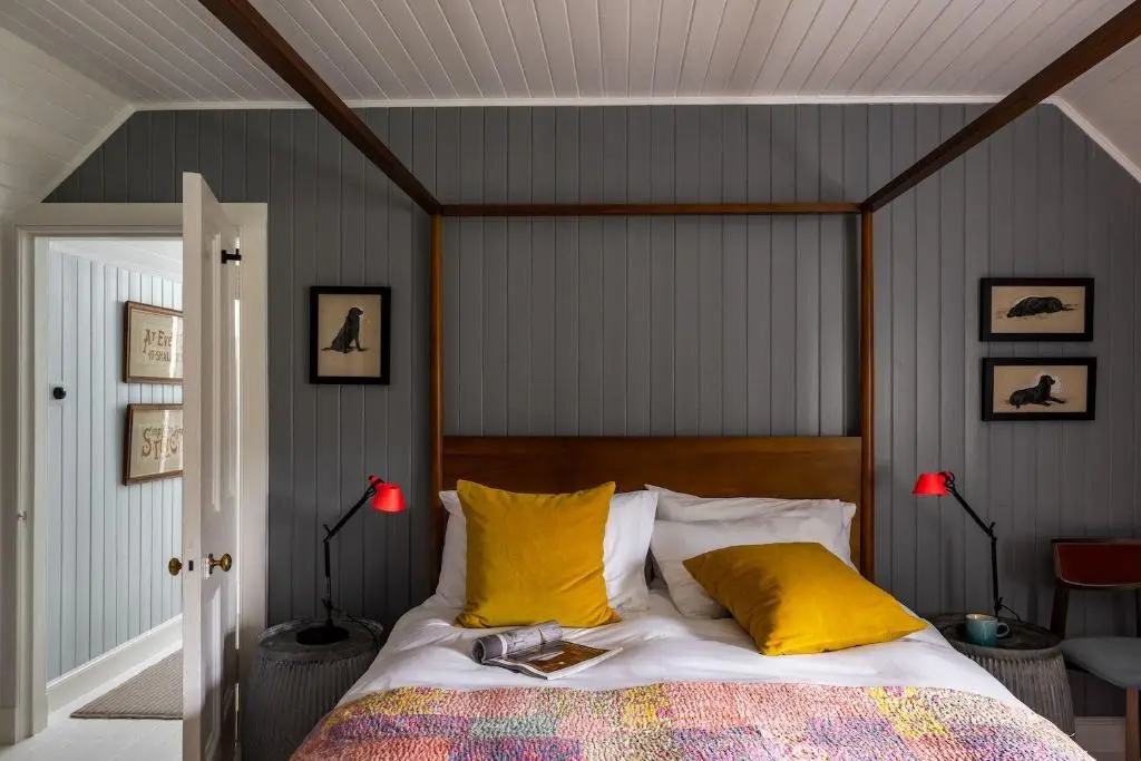 a bedroom with a bed with yellow pillows at Cuttieshillock in Banchory