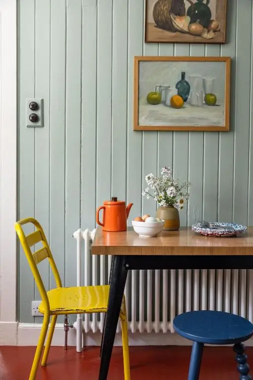 a table and a yellow chair in a room at Cuttieshillock in Banchory