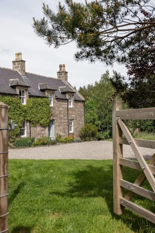 an old house with a gate in front of it at Cuttieshillock in Banchory