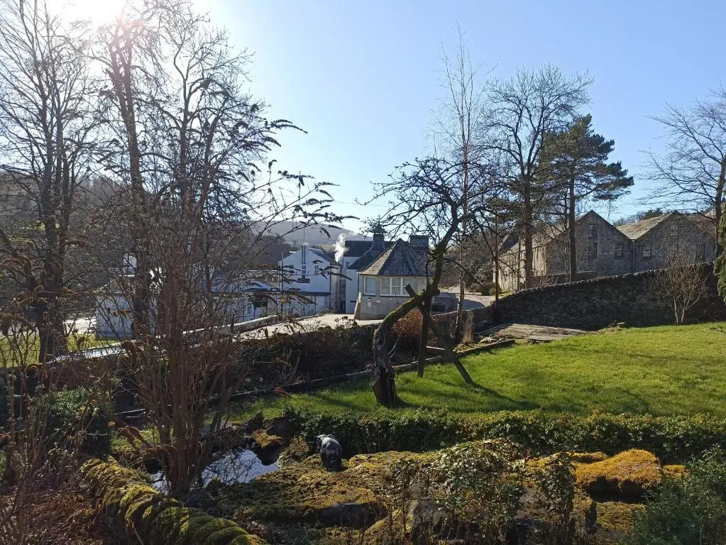 a garden with a pond in front of a house at Abbeyfield B&B in Dufftown