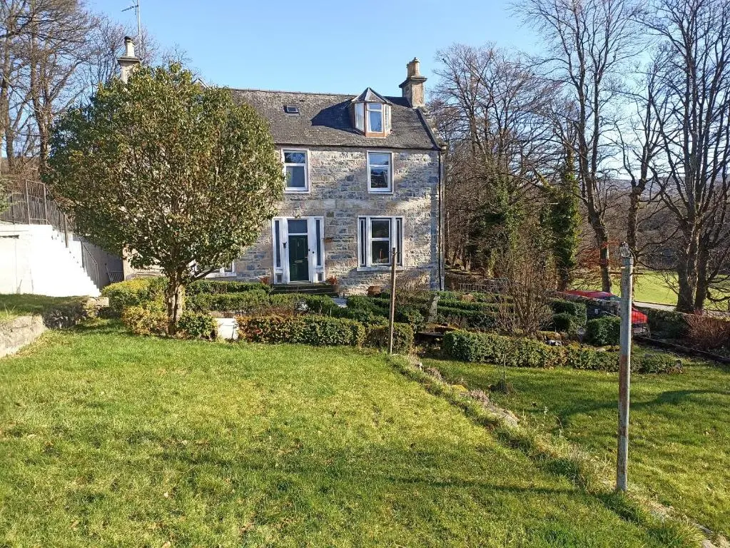 a large stone house with a grass yard at Abbeyfield B&B in Dufftown