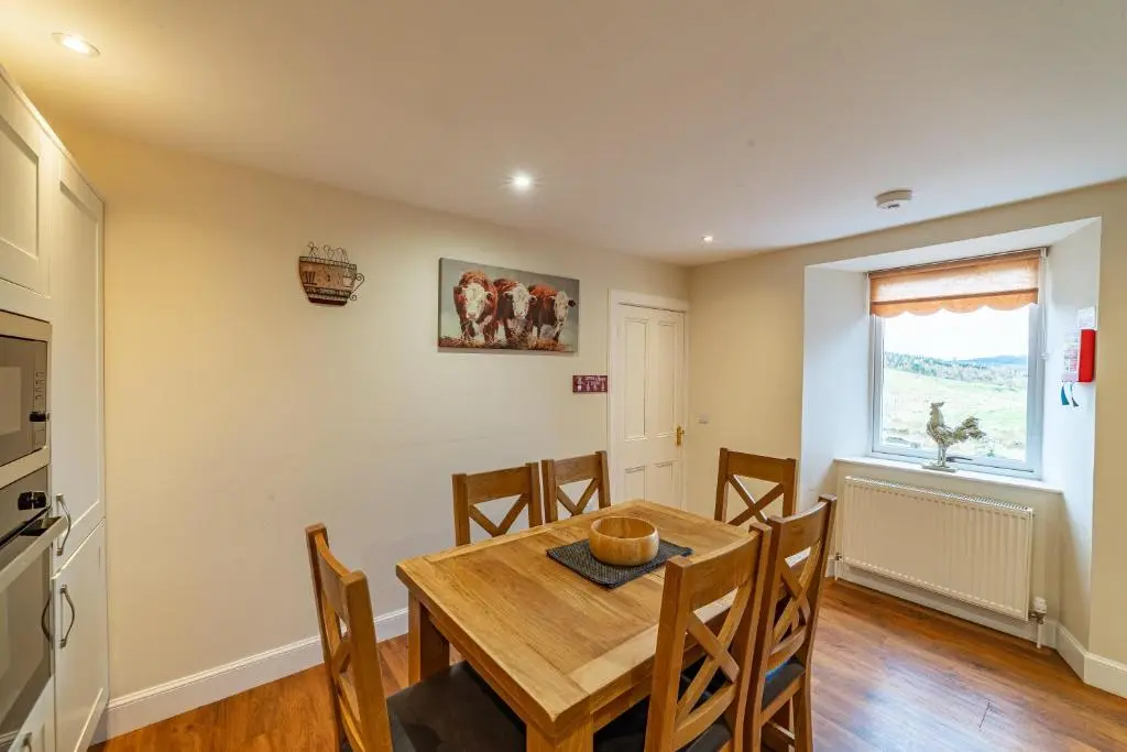 a kitchen and dining room with a wooden table and chairs at Stags View with Hot Tub in Blairgowrie