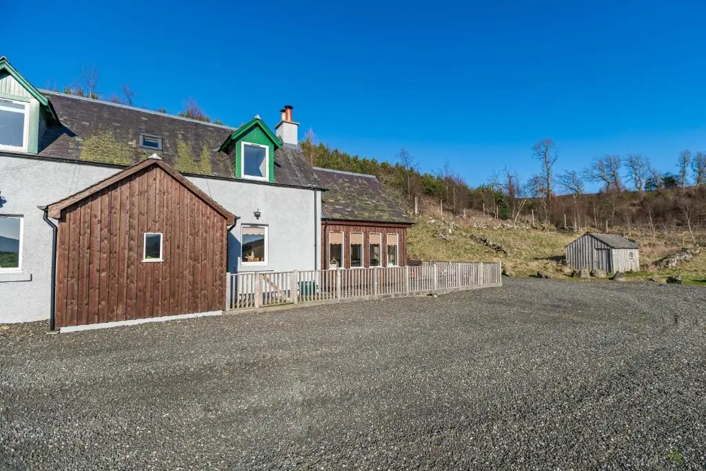 a house with a fence on the side of a road at Stags View with Hot Tub in Blairgowrie