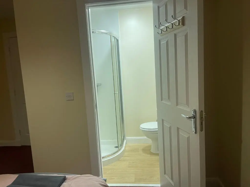 a bathroom with a shower and a toilet and a door at Morlich Guesthouse in Dingwall