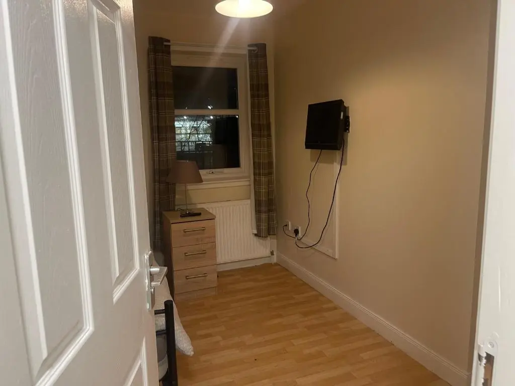 a hallway with a room with a window and a dresser at Morlich Guesthouse in Dingwall