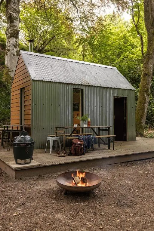 a fire pit in front of a cabin with a grill at North Lodge & River Cabin in Banchory