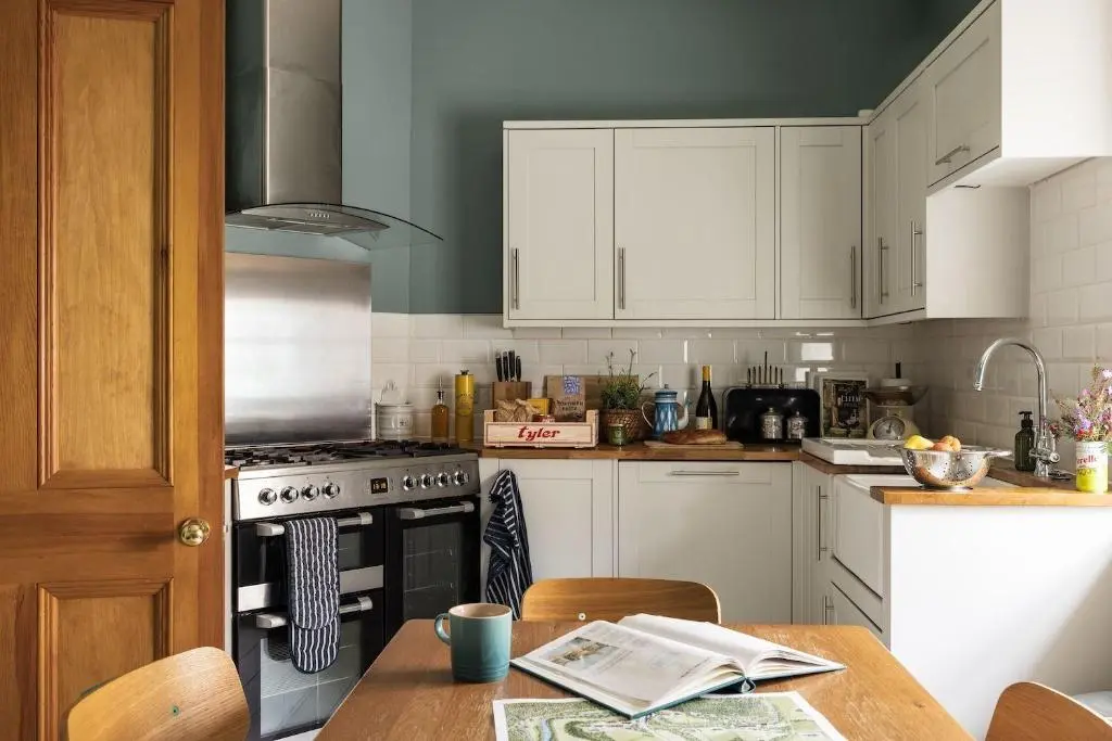a kitchen with white cabinets and a stove at North Lodge & River Cabin in Banchory