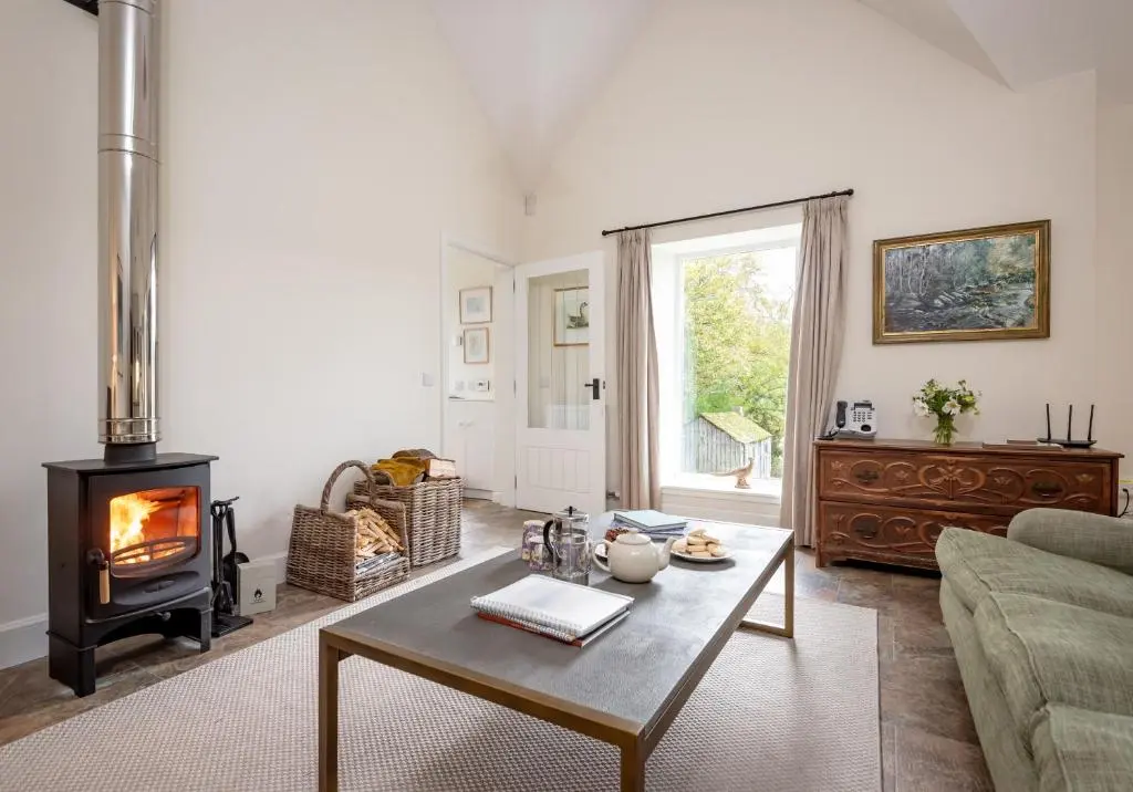 a living room with a wood stove and a couch at The Kennels in Ballogie