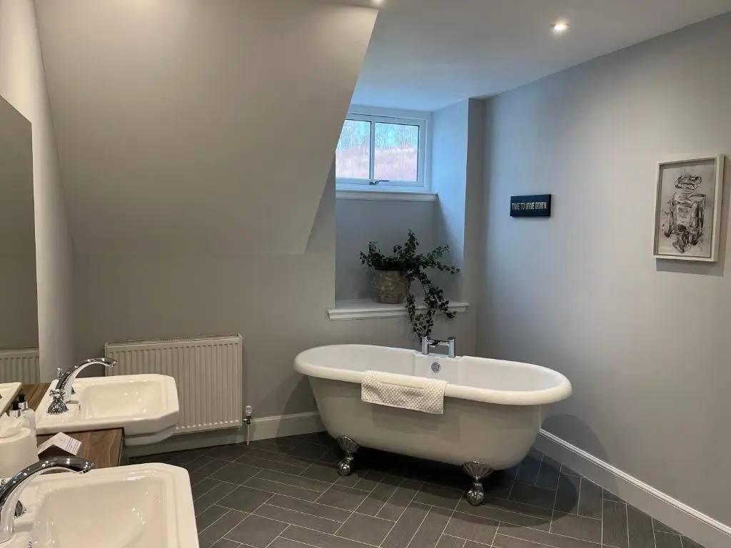 a white bathroom with a tub and a sink at The Stables with Hot Tub in Cray