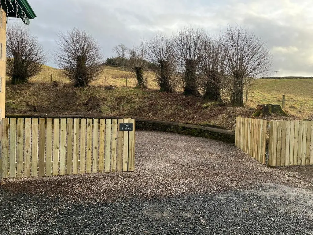 a wooden fence and a gate in a field at The Stables with Hot Tub in Cray