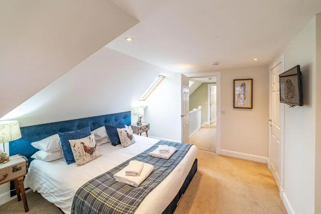 a bedroom with a large bed with a blue headboard at Mill House with Hot Tub in Cray