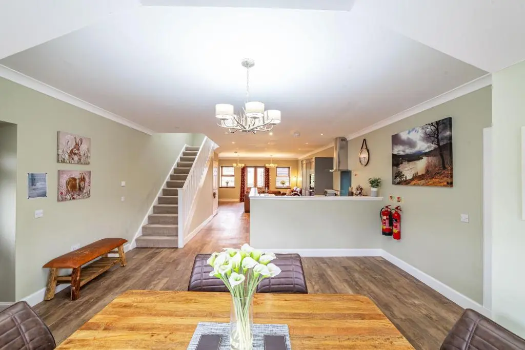 a living room with a table and a staircase at Mill House with Hot Tub in Cray