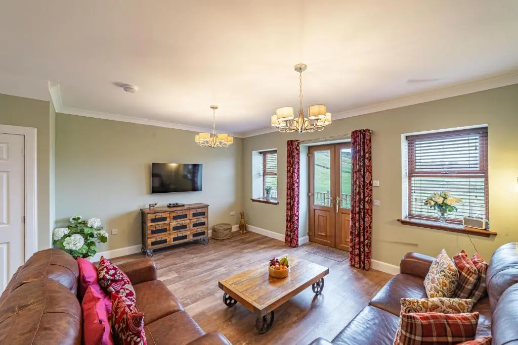 a living room with a couch and a table at Mill House with Hot Tub in Cray