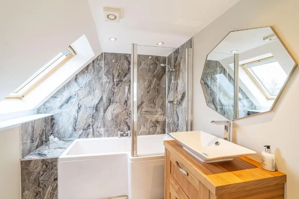 a bathroom with a sink and a mirror at Mill House with Hot Tub in Cray
