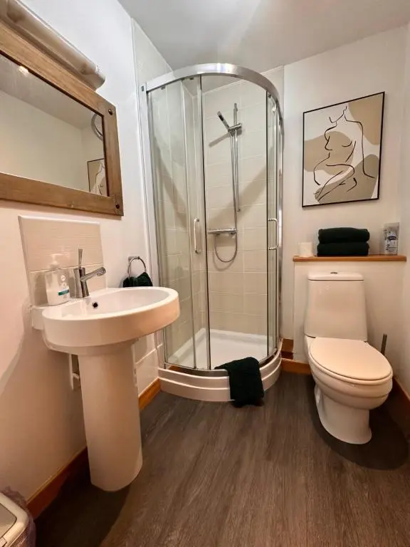 a bathroom with a shower and a toilet and a sink at City centre apartment next to Bus and Train Station in Inverness