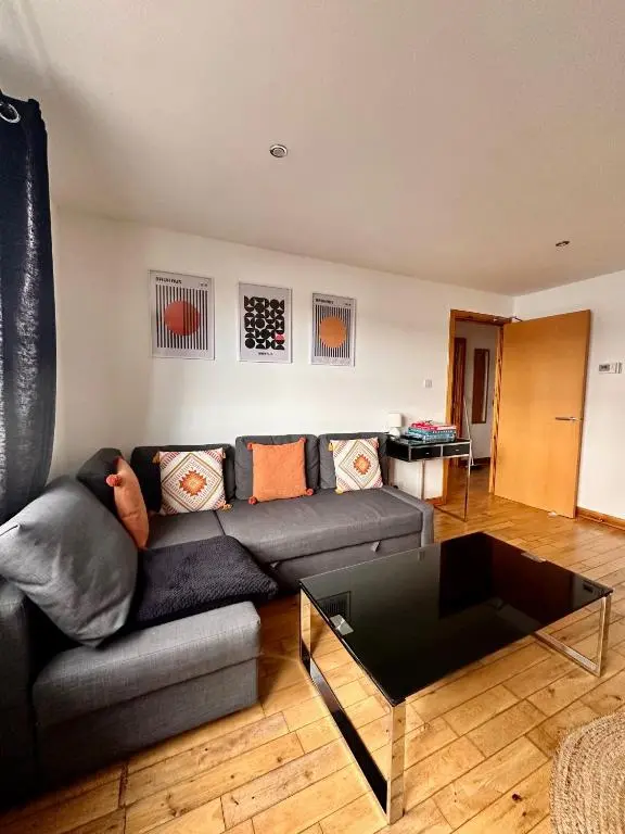 a living room with a couch and a coffee table at City centre apartment next to Bus and Train Station in Inverness