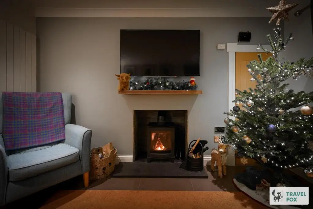 a living room with a christmas tree and a fireplace at Daisy Cottage - Two bed country retreat with hot tub in Turriff