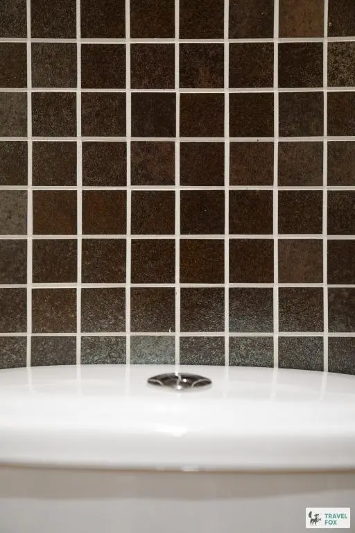 a bathroom with a black and white tiled wall at Daisy Cottage - Two bed country retreat with hot tub in Turriff