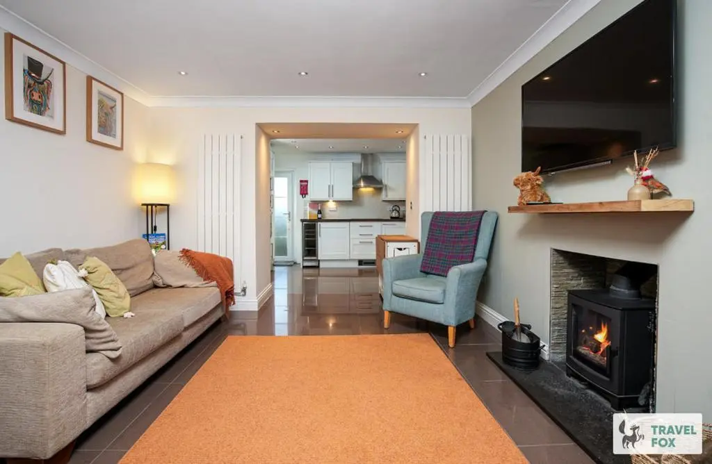 a living room with a couch and a fireplace at Daisy Cottage - Two bed country retreat with hot tub in Turriff