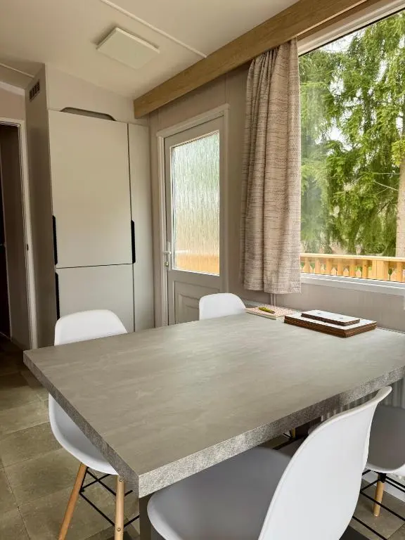 a kitchen with a table and chairs and a window at The Telford Van - Beautiful, luxury static caravan in Aberlour