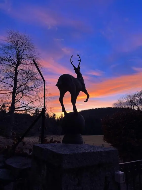 a statue of a person riding a goat at sunset at Craggan in Ballater