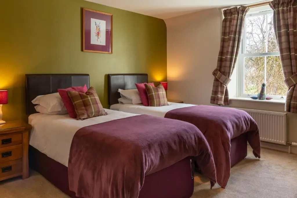 two beds sitting next to each other in a bedroom at Bridgend House B&B in Drumnadrochit