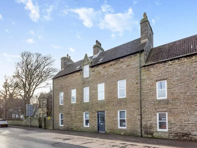 an old brick building with white windows on a street at LANGLEY LODGE 7 Double Bedrooms with SMART TVs, 6 Bathrooms, Fully Equipped Kitchen, Ample PARKING, Wifi, dishwasher, Garden, GREAT CENTRAL LOCATION Ideal for BUSINESS and TRADES TEAMS For Long Stays contact Langley Cottages & Serviced Apartments in Wick