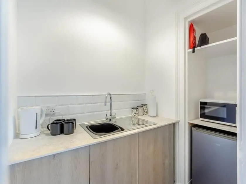 a kitchen counter with a sink and a microwave at LANGLEY LODGE 7 Double Bedrooms with SMART TVs, 6 Bathrooms, Fully Equipped Kitchen, Ample PARKING, Wifi, dishwasher, Garden, GREAT CENTRAL LOCATION Ideal for BUSINESS and TRADES TEAMS For Long Stays contact Langley Cottages & Serviced Apartments in Wick