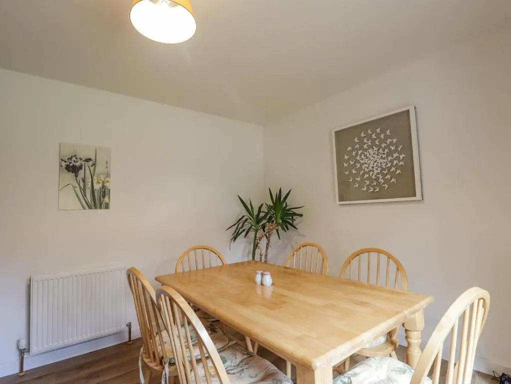 a dining room with a wooden table and chairs at Fresh Fields in Dingwall