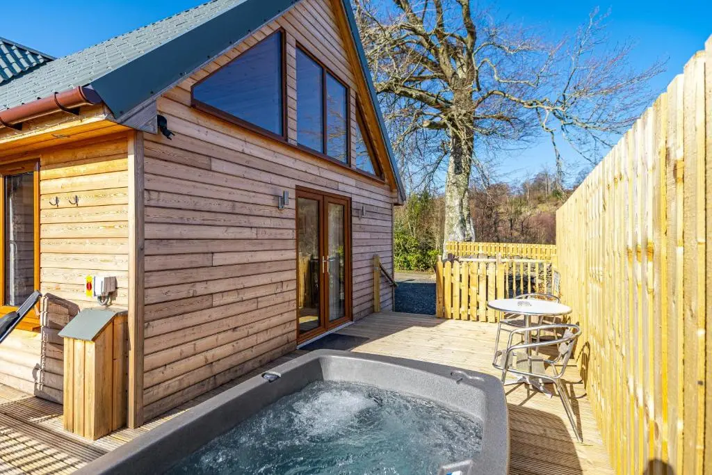 a hot tub on a deck next to a house at Roe Deer Lodge with Hot Tub in Cray