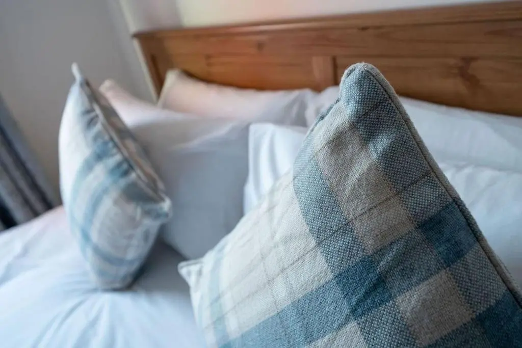 two pillows sitting on top of a bed at Hope House - 2 bedroom flat in Aberdeen