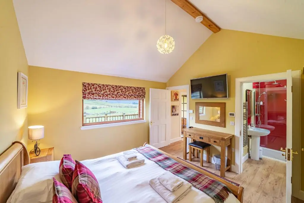 a bedroom with a bed and a desk at Pine Marten Lodge with Hot Tub in Cray